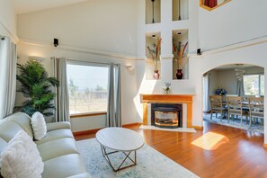 A spacious living room with a fireplace, a sofa, and a dining area. - Seaside Eureka Vacation Rental w/ Bay Views! (Eureka)