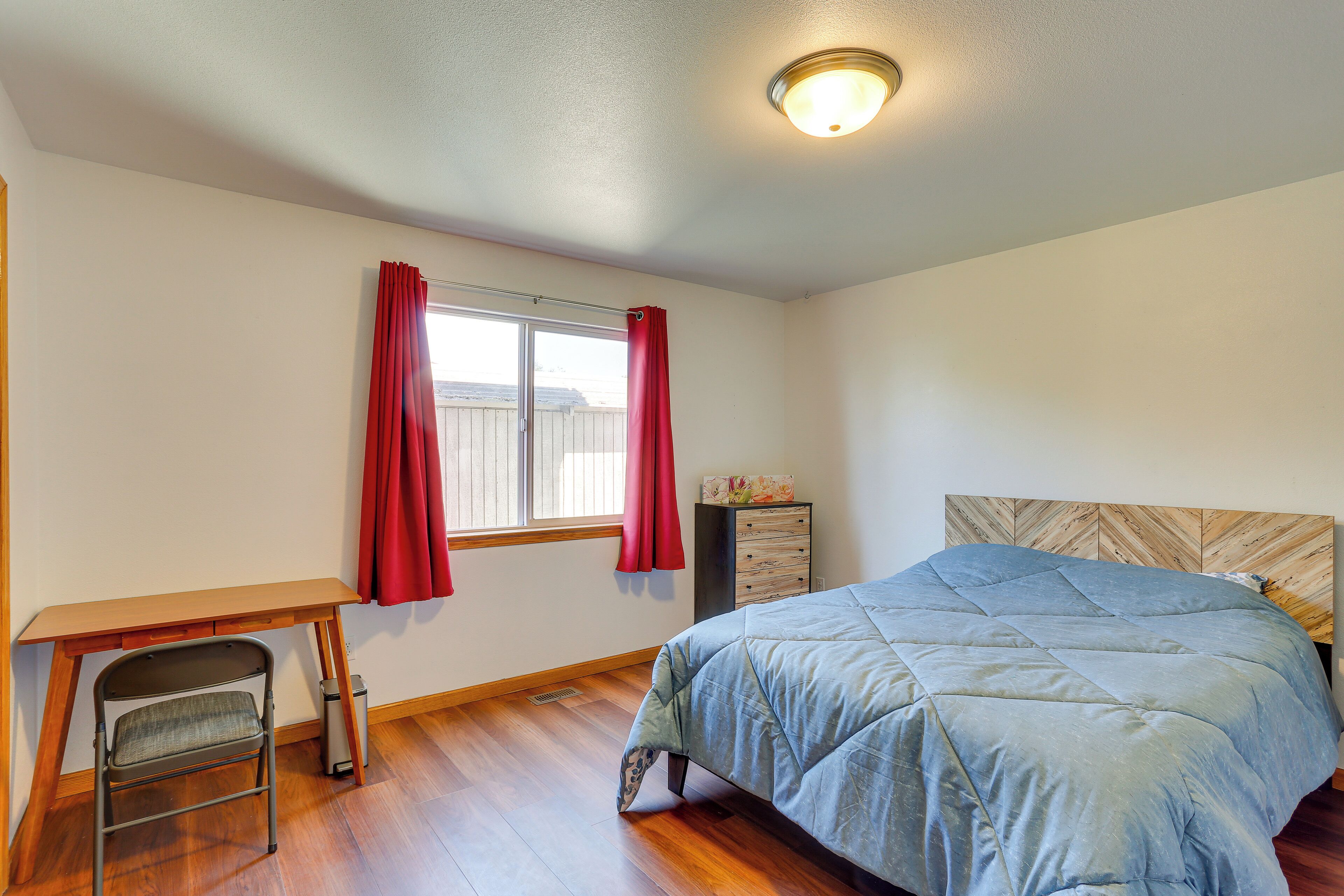 Un dormitorio con una cama, un escritorio y una silla.