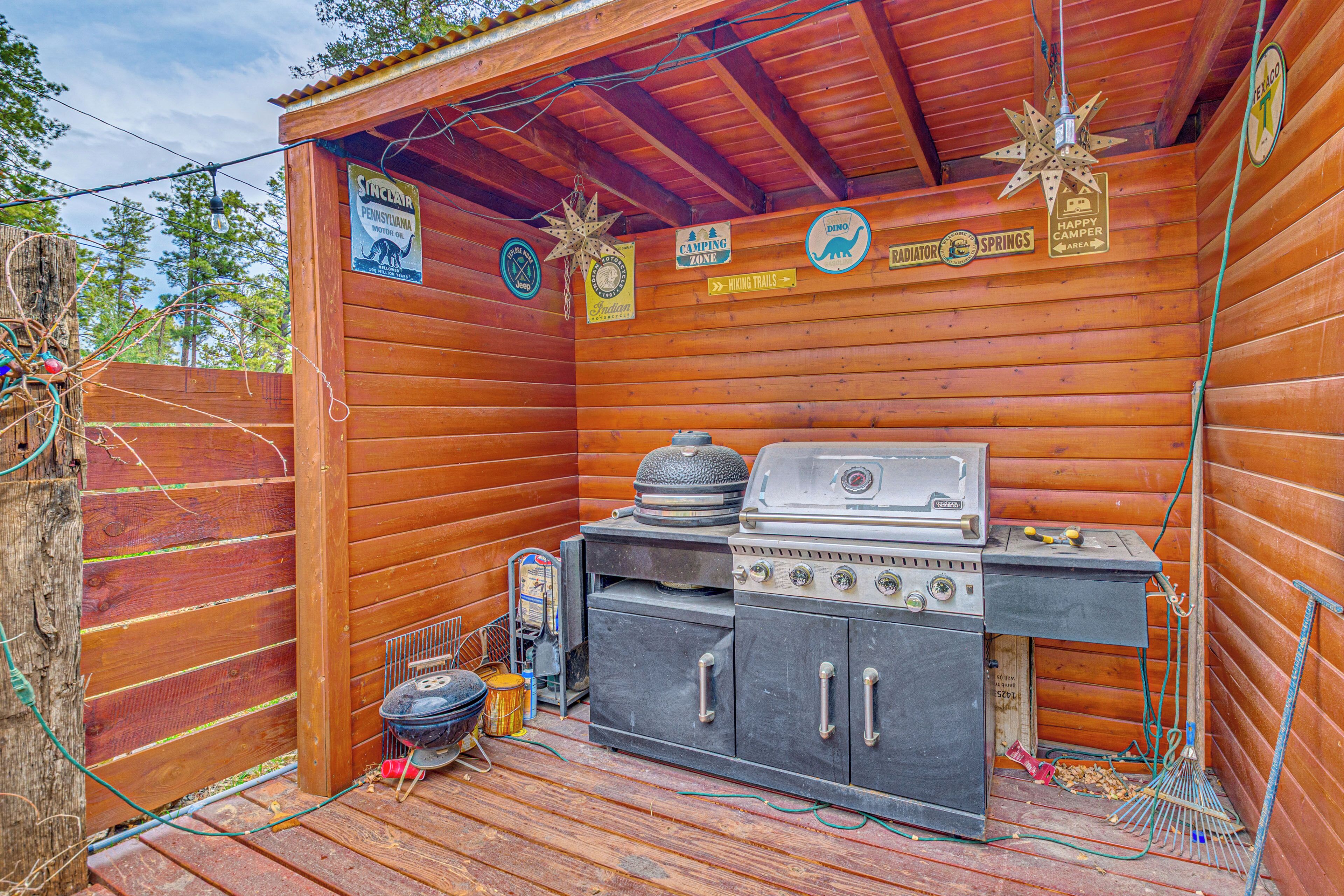 Une cabane en bois équipée d’un barbecue et d’ustensiles de cuisine, des panneaux indiquant une zone de camping et des sentiers de randonnée, ainsi qu’une décoration en forme d’étoile.