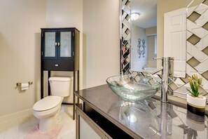 A modern bathroom with a glass bowl sink, a toilet, and a cabinet. - Pets Welcome: Convenient Family Home in Westland! (Westland)