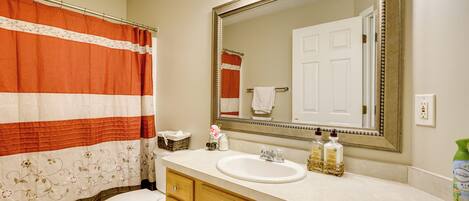 A bathroom with a toilet, sink, and mirror.