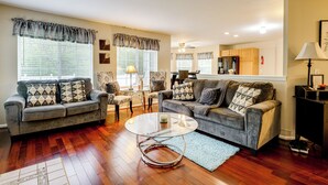 A living room with two sofas, a coffee table, and a dining area in the background. - Pets Welcome: Convenient Family Home in Westland! (Westland)