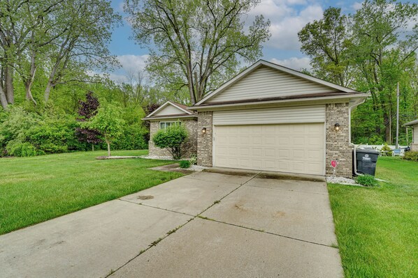 A residential house with a garage, a driveway, and a well-maintained lawn.