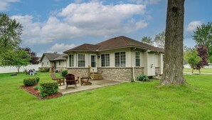 A two-story house with a front porch, a lawn, and a large tree. - Pets Welcome: Convenient Family Home in Westland! (Westland)