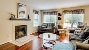 A living room with a fireplace, a sofa, a coffee table, and a lamp. - Pets Welcome: Convenient Family Home in Westland! (Westland)