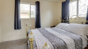 Una camera da letto con un letto, tende, una ventola a soffitto e una finestra.