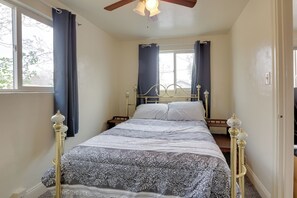A bedroom with a bed, curtains, a ceiling fan, and a window. - Home Near Reno Industrial Center & Med Centers (Sparks)