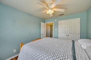 A bedroom with a bed, a ceiling fan, and two white doors. - 8 Mi to Fort Hood! Family Home w/ Patio & Yard (Killeen)
