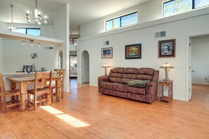 A spacious living area with a wooden dining table, a brown sofa, and a ceiling fan. - Hot Tub & Pool! Resort-style Las Cruces Retreat (Las Cruces)