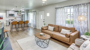 Ein modernes Wohnzimmer mit Sofa, Couchtisch und Essbereich.
