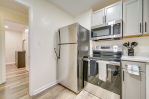 A modern kitchen with stainless steel appliances, a microwave, oven, and cabinets.