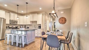 A modern kitchen with white cabinets, stainless steel appliances, and a central island with bar stools. - Modern Black Mountain Cottage: 17 Mi to Asheville! (Black Mountain)