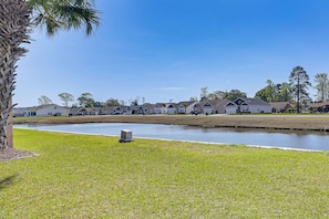 A residential area with houses, a grassy lawn, and a body of water. - Water-view Patio! Condo 2 Mi to Surfside Beach (Surfside Beach)