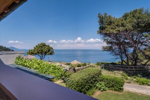 A coastal view with a stone wall, a tree, and a clear sky. - Prekrasan pogled na more.Apartman Palma 2. (Mali Lošinj)