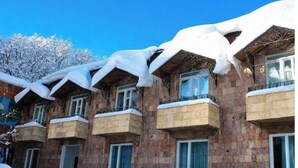 Un immeuble doté de nombreux balcons recouverts de neige.