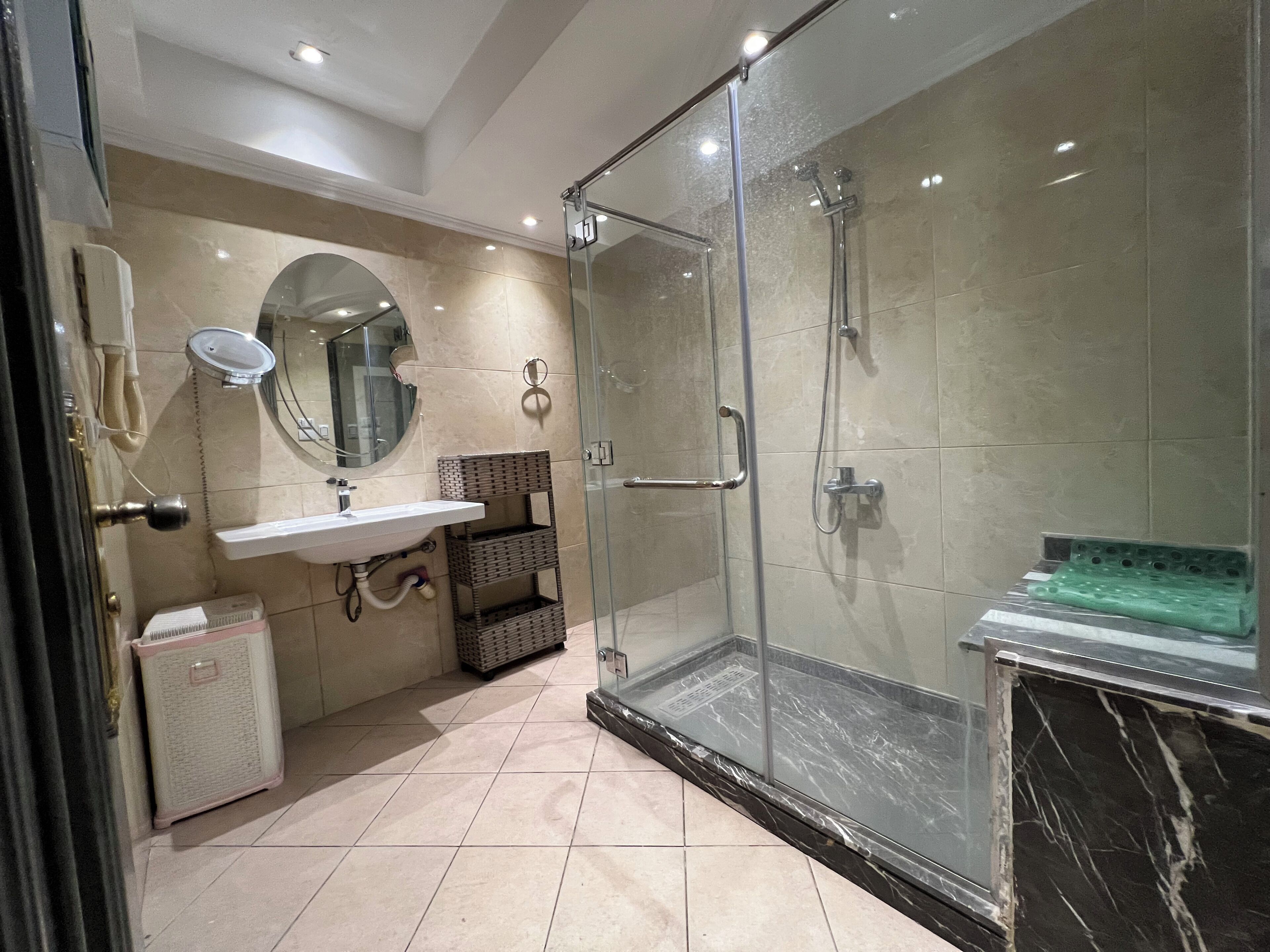 A modern bathroom with a glass shower enclosure, a sink with a mirror, and a toilet.