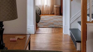 Ein Flur mit Treppe, einer Lampe, einem kleinen Tisch und einem Korbwäscheschrank.