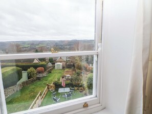 A window view of a residential area with a lawn, a shed, and a small garden. - Natures Retreat (Matlock)