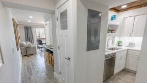 A modern kitchen with white cabinets, a stainless steel sink, and a built-in dishwasher. - 112 Arrowhead Unique Lakefront 2br At Kingston 2 Bedroom Condo (Myrtle Beach)