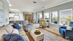 Un espacio habitable amplio con sofá, sillones, una mesa de comedor y vistas al exterior.