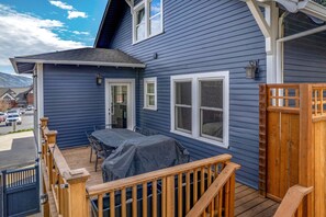A two-story house with a deck, a covered patio, and a wooden fence. - State Of Chill 4 Bedroom Home (Hood River)