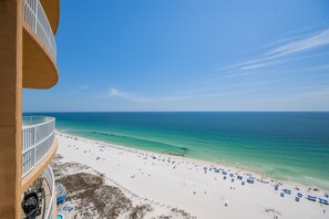 A beach view from a balcony with a clear sky, a sandy beach, and a calm sea. - Phoenix Gulf Towers 1803 3 Bedroom Condo (Orange Beach)