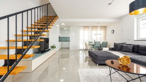 A modern living space with a staircase, a dining area, and a sofa. - New vacation home in Nin, 100m to the beach l 3 bedrooms l 2 bathrooms l 6 pers. l All-inclusive. (Nin)