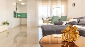 A modern living room with a glass coffee table, a sofa, and a dining area in the background. - New vacation home in Nin, 100m to the beach l 3 bedrooms l 2 bathrooms l 6 pers. l All-inclusive. (Nin)