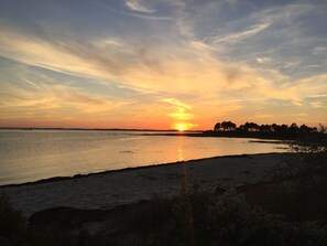 A sunset over a calm body of water with a distant shoreline. - Villa Charmence Ideal, quiet location 100M from the beach and oyster port (Andernos-les-Bains)