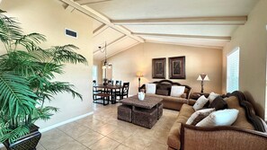 A spacious living room with a dining area, a large potted plant, and a cozy seating arrangement. - 925 Maple Ave, 5 Min walk to Free Beach Entrance (Marco Island)