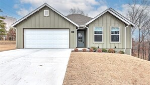 Ein eingeschossiges Haus mit Garage, Eingangstür und einer kleinen Veranda.