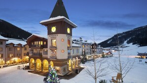 Un hotel con una torre de reloj, varios edificios y un paisaje nevado.