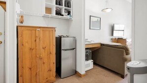 Una cocina compacta con un mueble de madera, un refrigerador y un horno empotrado.