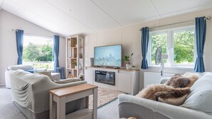 A living room with a sofa, a TV, a small table, and a bookshelf.