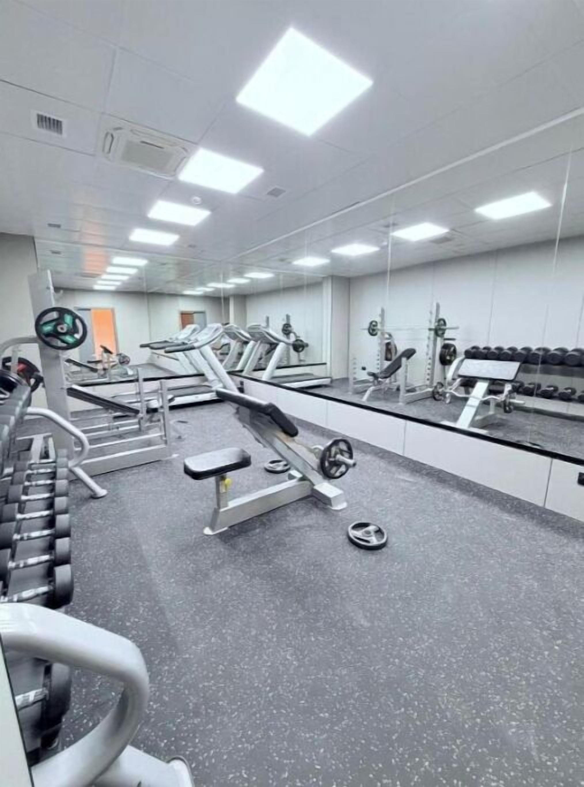 A gym with treadmills, weight machines, and free weights.
