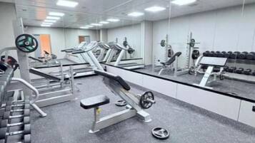 A gym with treadmills, weight machines, and free weights.