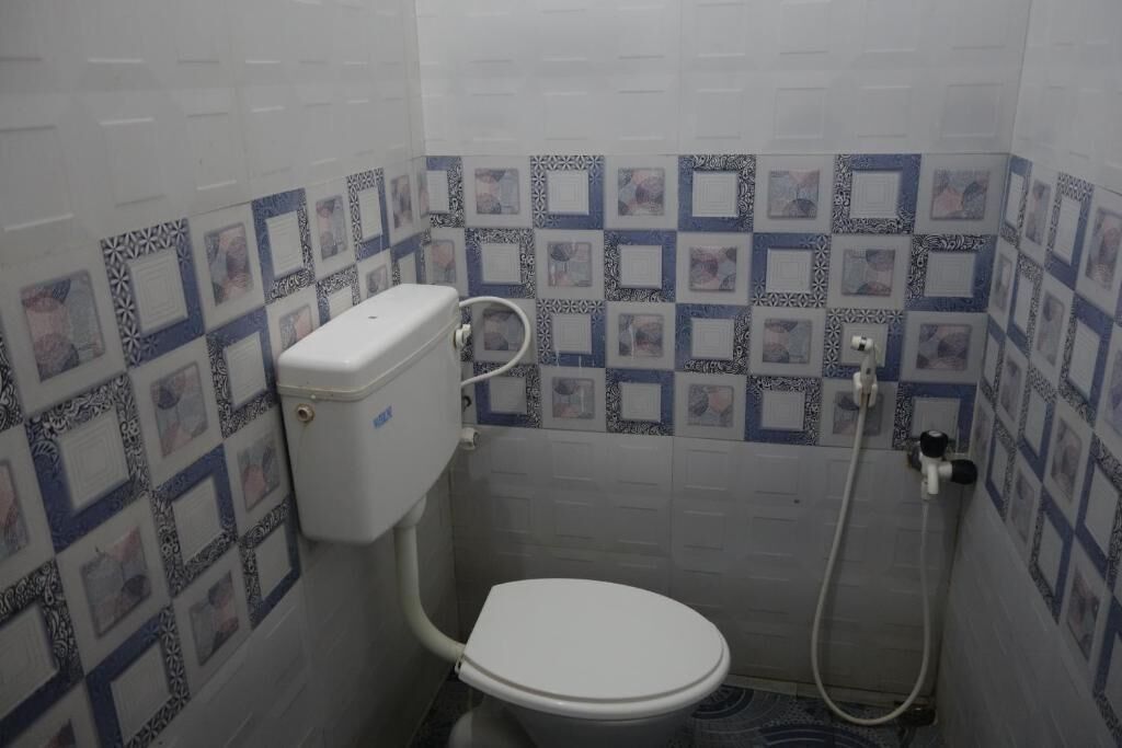 A small bathroom with a toilet, a shower, and tiled walls.