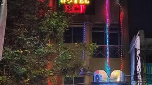 A hotel with neon signs, a bakery, and a pharmacy. - Hotel HCB (Brahmapur)