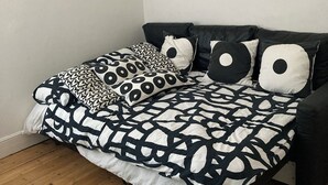 Un dormitorio con cama, almohadas y una alfombra.