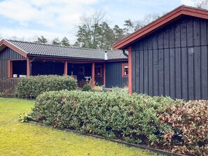 A two-story building with a covered porch and a fenced yard. - 4 Star Holiday Home in Eldsberga (Eldsberga)