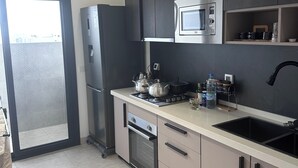 Une cuisine moderne équipée d’un four à micro-ondes, d’une cuisinière, d’un four et d’un évier.