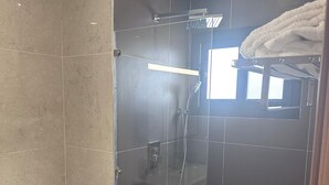 Une salle de bain moderne avec une douche à parois de verre, des toilettes et un lavabo.