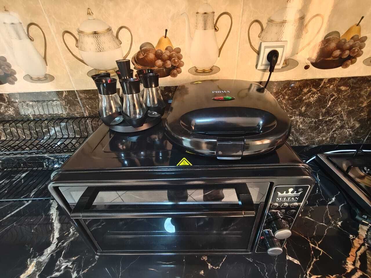 A kitchen with a black stove, a coffee maker, and a microwave.