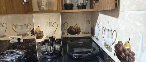 A kitchen with a stove, a coffee maker, and a blender on the countertop.