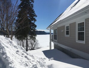 Ein Haus mit verschneitem Dach und einer Veranda.