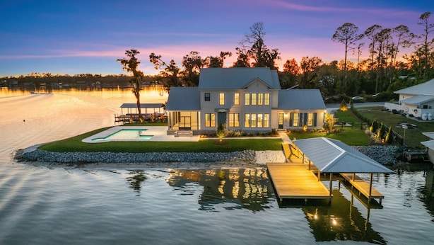 Une propriété située au bord de l’eau, comprenant une grande maison, une piscine et un quai.