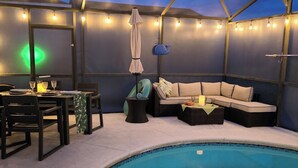 A poolside area with a pool, seating, and string lights. - Disney 10 mins private house privacy screen pool, gated community no resort fees (Kissimmee)