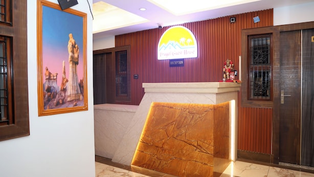 A reception area with a reception desk, a framed picture on the wall, and a sign above the desk. - Pragati Guest House (Gorakhpur)