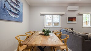 Een eetgedeelte met een houten tafel, stoelen en een bank.