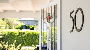 Een gebouw ingang met een bord met het nummer '50' en een decoratieve glazen deur.